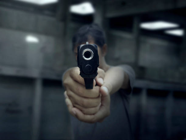 istock Man pointing a gun at the target on dark background 1358881489