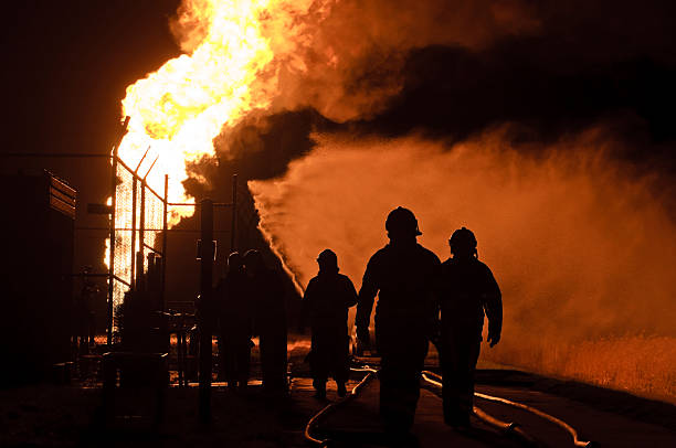istock silhouette of firefighters in action by night 135888243