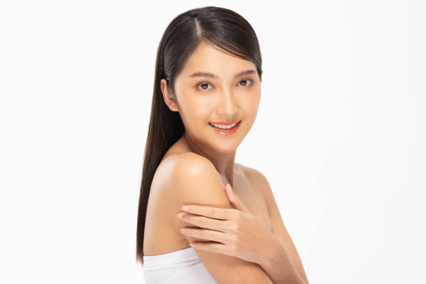 istock Wellness Beautiful Young Asian Woman Looking While Touching Shoulder feeling so happy and cheerful with healthy Clean and Fresh skin,isolated on white background,Beauty Cosmetics Concept 1358889626