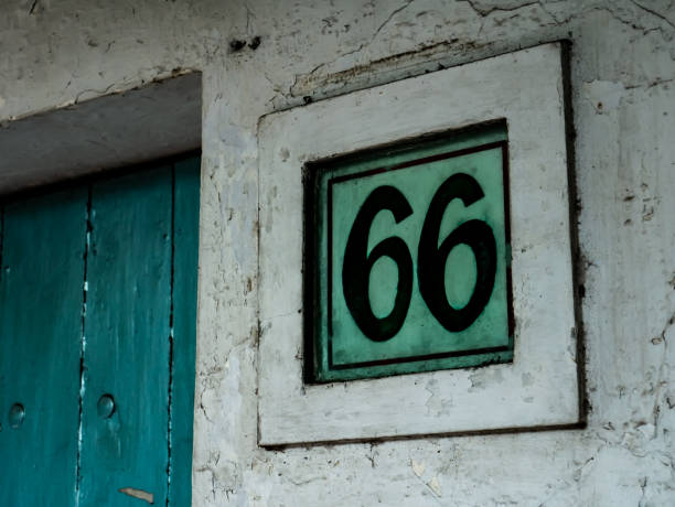 green house number marked "66" on the outskirts of town The design of the house number is often considered one of the aesthetic elements number 66 stock pictures, royalty-free photos & images