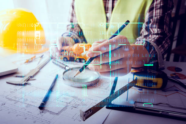 istock Two colleagues discussing data working and tablet, laptop with on on architectural project at construction site at desk in office 1358892238