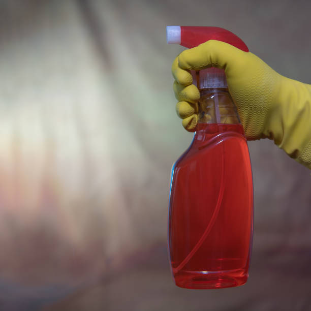 istock Cleaning dirty surfaces with a red cleaning agent. Hand in a rubber glove. square format 1358894092