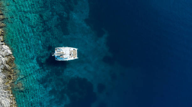 istock Beautiful sailing catamaran anchored next to the island 1358902899