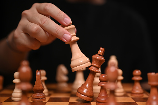 Businessman moving chess piece and checkmate during competition. Successful business competition leader concept.