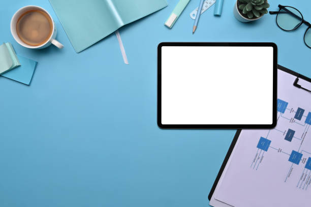 istock Top view digital tablet, supplies and financial documents on blue background. 1358905007
