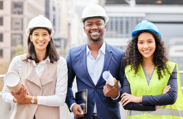 istock Cropped portrait of three young engineers standing with blueprints on a construction site 1358906468