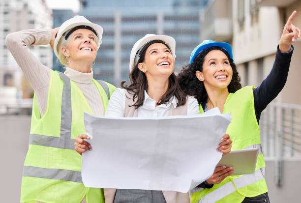 istock Cropped shot of three attractive female engineers reading a blueprint while working on a construction site 1358906478