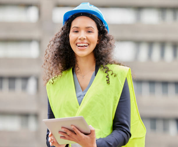 istock Cropped portrait of an attractive young female engineer working on a tablet while standing on a construction site 1358906483