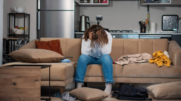 view of a young female who is addicted to cocaine. she is in a drug crisis. sitting on a sofa. she messed up everywhere and she doesn’t know what to do. she doesn’t have enough money to buy cocaine. she got involved in the drug environments in college. - garment emotional stress equipment household equipment imagens e fotografias de stock