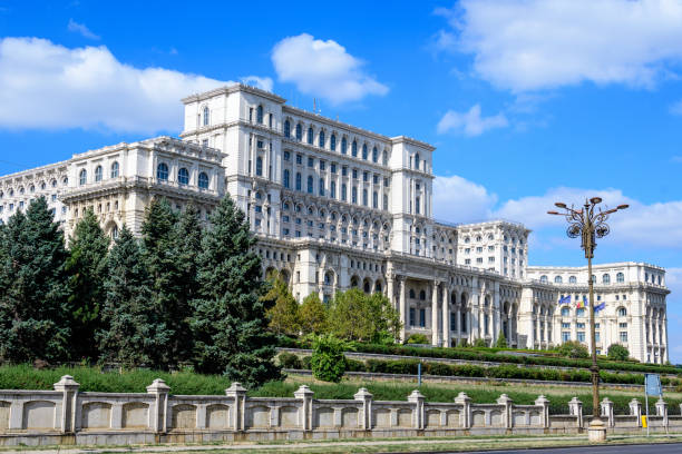 большое здание дворца парламента, также известного как народный дом (casa poporului) на площади конститутивей (piata constitutiei) в солнечный осенний день - constitutiei стоковые фото и изображения
