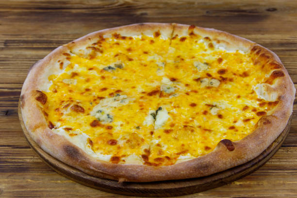 istock Pizza Four cheese on a wooden background 1358911337