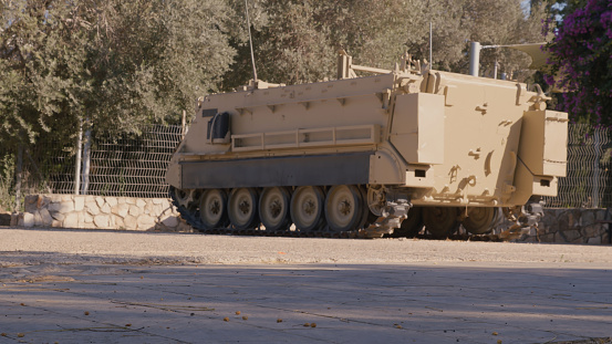 Armored personnel carrier near metal fence - view from the back