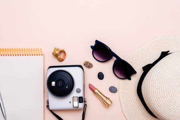 istock summer travel accessories. camera, hat, glasses and top view on a light background. with space for your text 1358915106