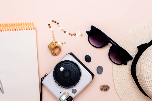 istock summer travel accessories. camera, hat, glasses and a flat Notepad top view lay flat on a light background 1358915108