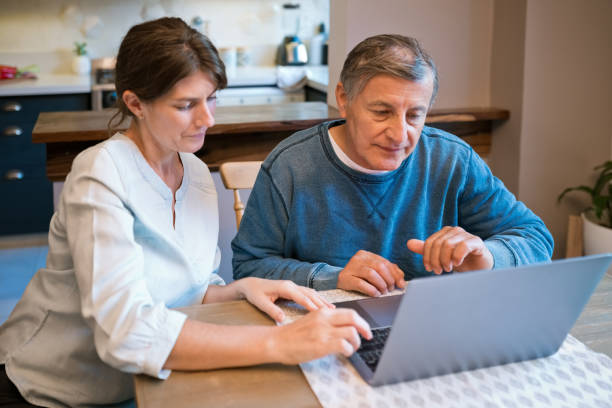 istock Nurse teaching laptop to senior man at home 1358926250