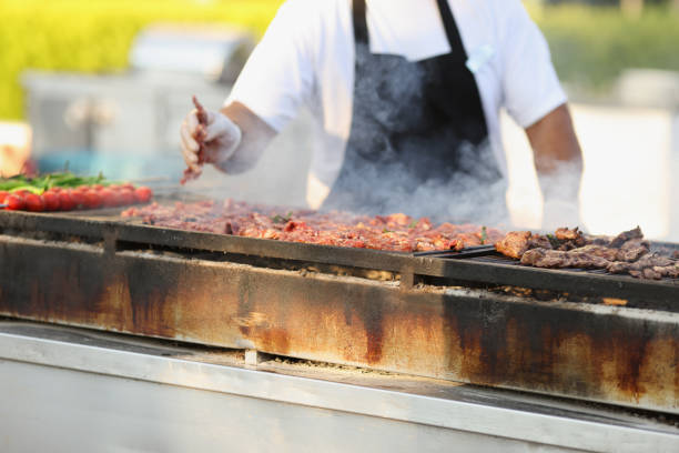 profesjonalny kucharz smaży świeże mięso na grillu na świeżym powietrzu - welldone zdjęcia i obrazy z banku zdjęć