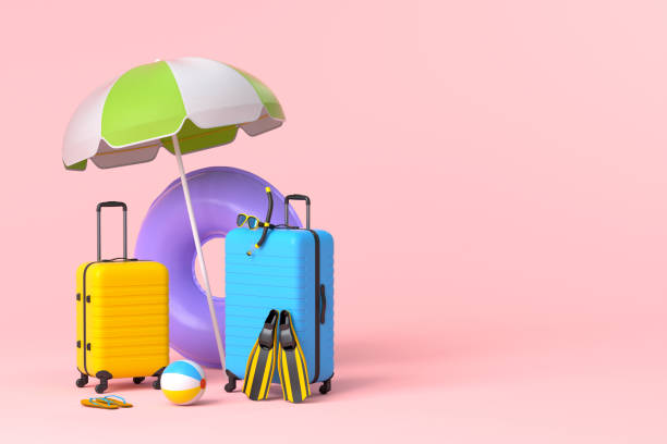 istock Suitcase with beach umbrella and inflatable ring on pink background. 1358928795