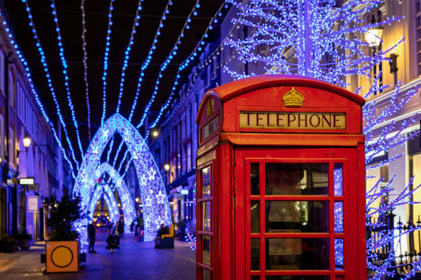 ロンドン中心部の焦点が当てがされていないクリスマスの装飾の前にある赤い電話ブース - pay phone telephone telephone booth red ストックフォトと画像