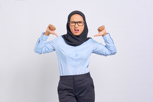 Portrait of excited young Asian woman pointing at herself with proud isolated on white background