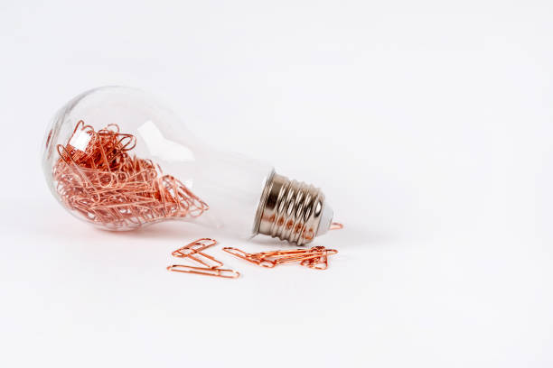 istock A light bulb filled with copper paper clips on a white background. Stationery objects 1358932711