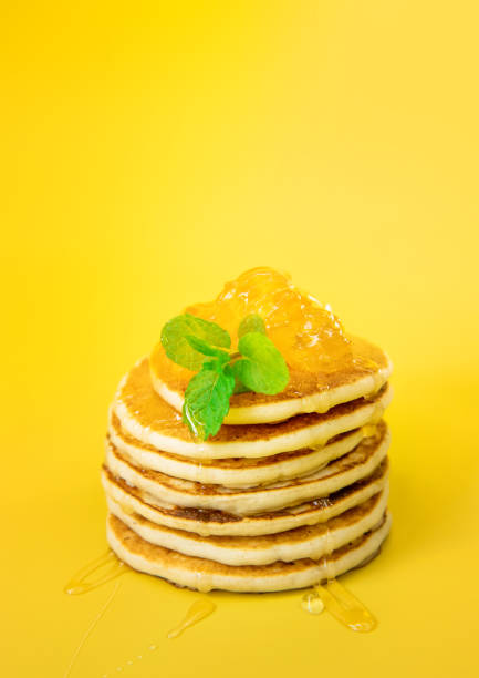 istock stack of freshly home made pancakes isolated over bright yellow background, traditional americal breakfast meal, studio photo shot 1358935093