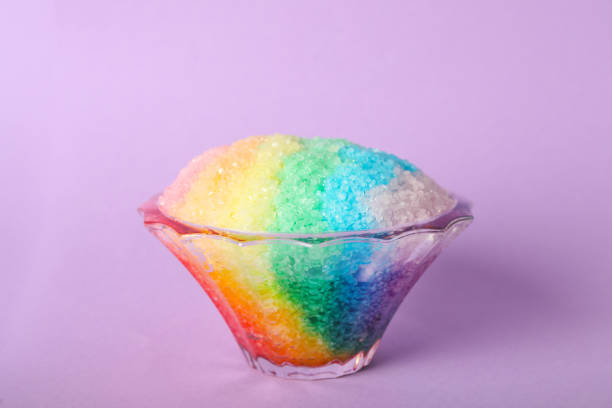 istock Rainbow shaving ice in glass dessert bowl on violet background 1358936879