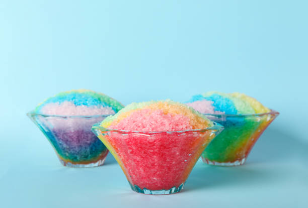 istock Rainbow shaving ice in glass dessert bowls on light blue background 1358938719