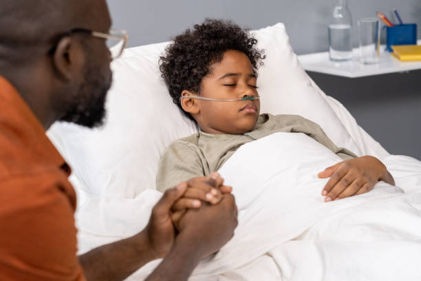 istock Boy lying in bed at hospital ward 1358938857