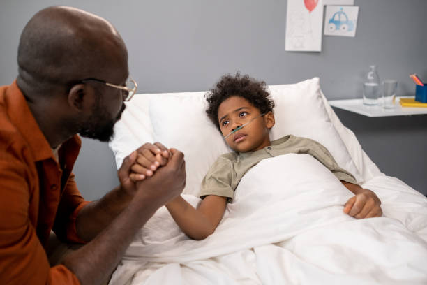 istock Father visiting his son at hospital ward 1358938963