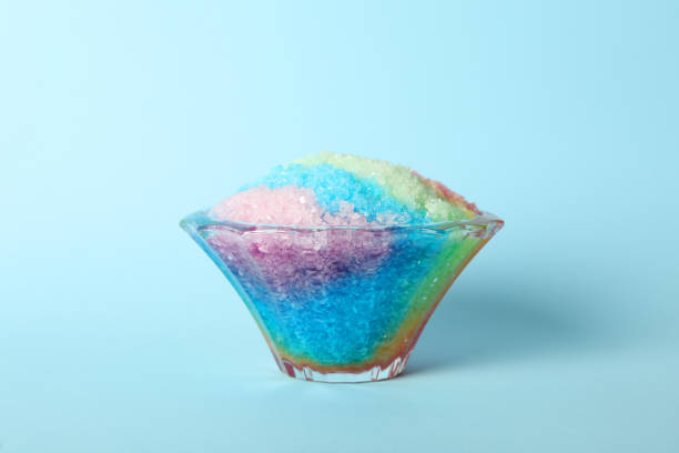 istock Rainbow shaving ice in glass dessert bowl on light blue background 1358939269
