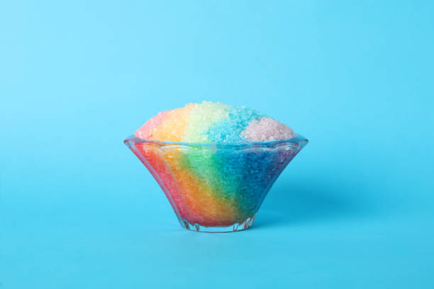 istock Rainbow shaving ice in glass dessert bowl on light blue background 1358940413