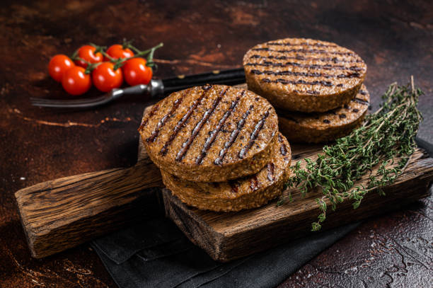 bbq polpette di hamburger di carne alla griglia a base vegetale, cotolette vegane su tavola di legno con erbe. sfondo scuro. vista dall'alto - cooked roasted cooking fried foto e immagini stock