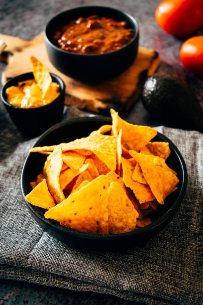 istock Mexican nachos with guacamole, cheddar cheese and chili. 1358940905