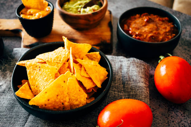 istock Mexican nachos with guacamole, cheddar cheese and chili. 1358940909