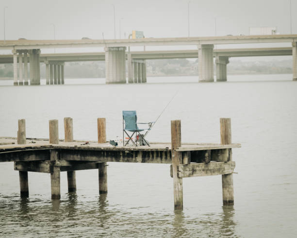 silla de campamento plegable con aparejos de pesca y caña de pie en el embarcadero del muelle en lake ray hubbard, texas, ee. uu. - hubbard texas fotografías e imágenes de stock