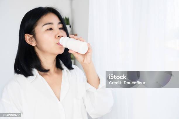 Asian Woman Drinking Yogurt Fermented Milk From Bottle Stock Photo - Download Image Now