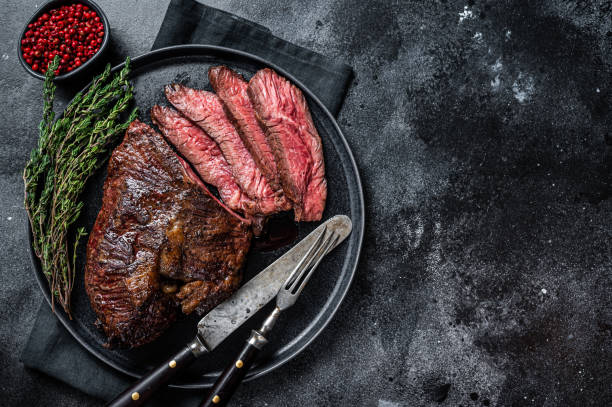 istock Grilled hanger or Onglet beef meat steak on a plate with thyme. Black background. Top View. Copy space 1358941787