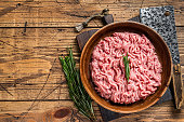 Chicken or turkey mince meat, raw Poultry in a wooden plate. Wooden background. Top View. Copy space