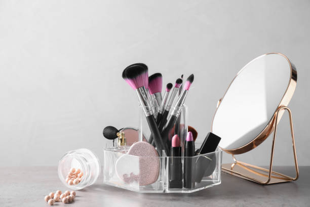 istock Make up brushes, cosmetic products and mirror on grey table 1358942828