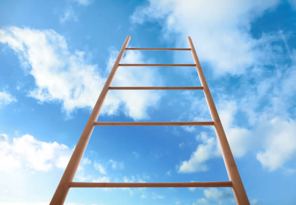 istock Wooden ladder against blue sky with clouds, low angle view 1358943266