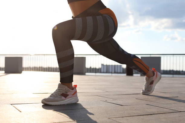 istock Young woman doing exercise outdoors in morning, closeup 1358944021