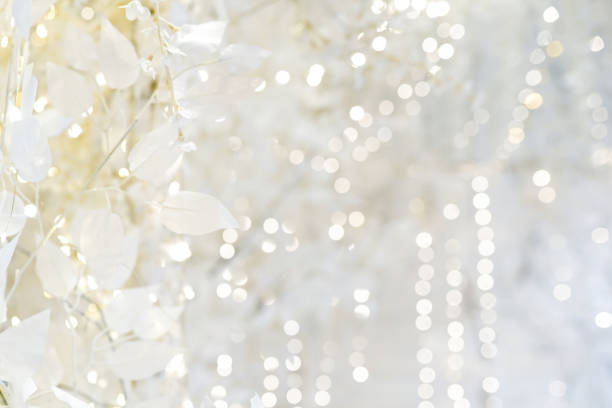 istock Light white abstract Christmas background with lights and leaves 1358945358