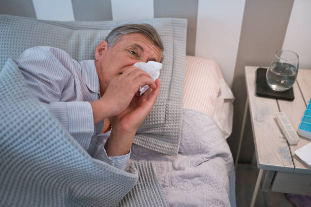 istock Sick senior man lying in bed 1358947006