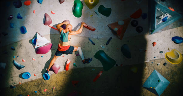 istock Strong Experienced Rock Climber Practicing Solo Climbing on Bouldering Wall in a Gym. Man Exercising at Indoor Fitness Facility, Doing Extreme Sport for His Healthy Lifestyle Training. Shot from Back. 1358948283