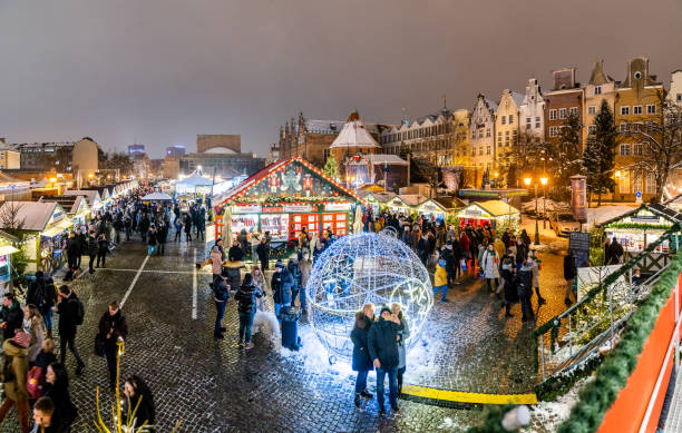 Christmas market in Gdansk (Jarmark Bożonarodzeniowy). Christmas fair in Gdansk - people strolling along the "Targ Węglowy" Christmas Market with a street food and souvenirs. gdansk stock pictures, royalty-free photos & images