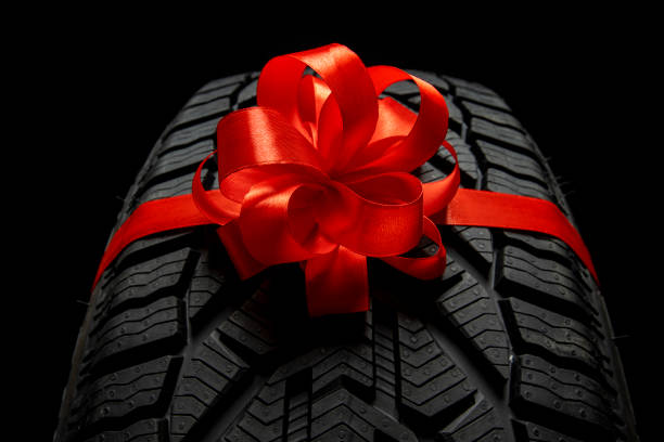 istock black isolation rubber tire, on the grey backgrounds in a bow for christmas 1358949345