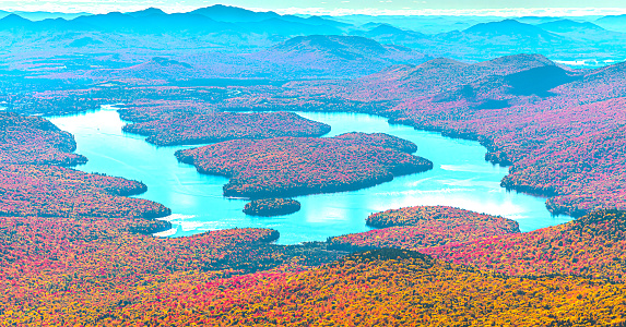 An aerial view of Lake Placid in New York surrounded by vibrant red foliage.