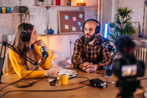 istock Two hosts in headphones recording podcast in broadcasting 1358951228