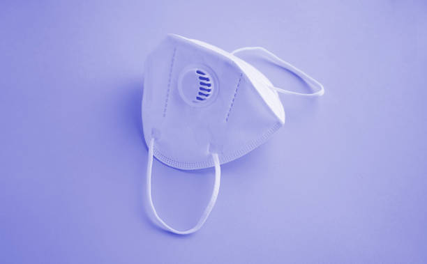 istock High angle view of a white face mask on very pery background 1358951423