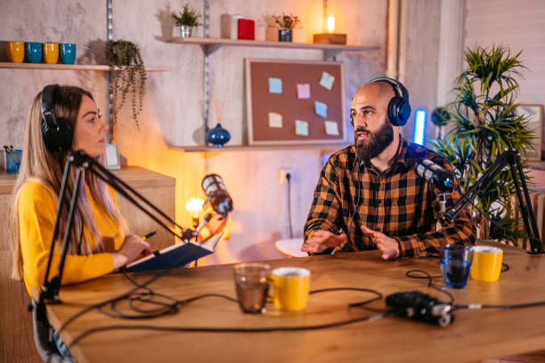 istock Two hosts in headphones recording podcast in broadcasting 1358952068